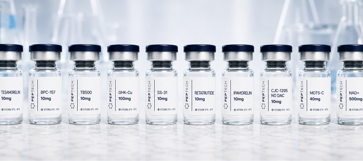 A row of small clear glass vials with black caps and white labels, arranged in a line on a light surface with a blurred laboratory background.